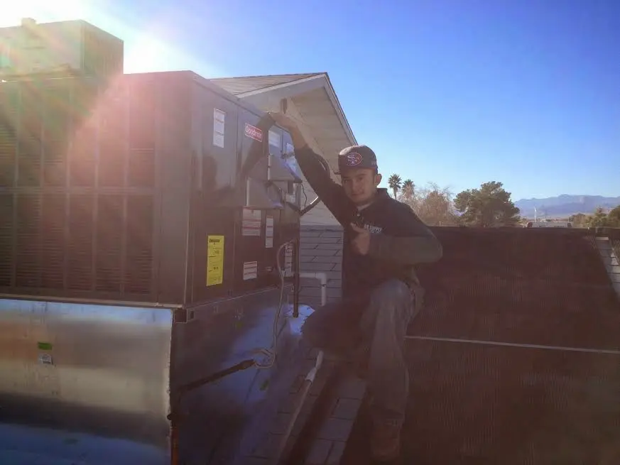 HVAC technician performing Boiler Repair on a rooftop unit in Sequim